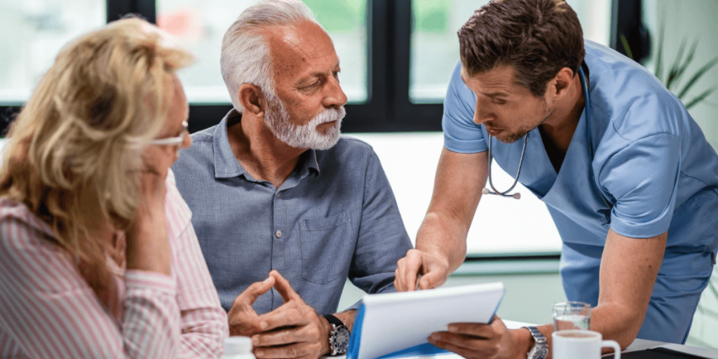 Doctor explaining medical report to an elderly couple during a consultation, discussing health results and treatment options.